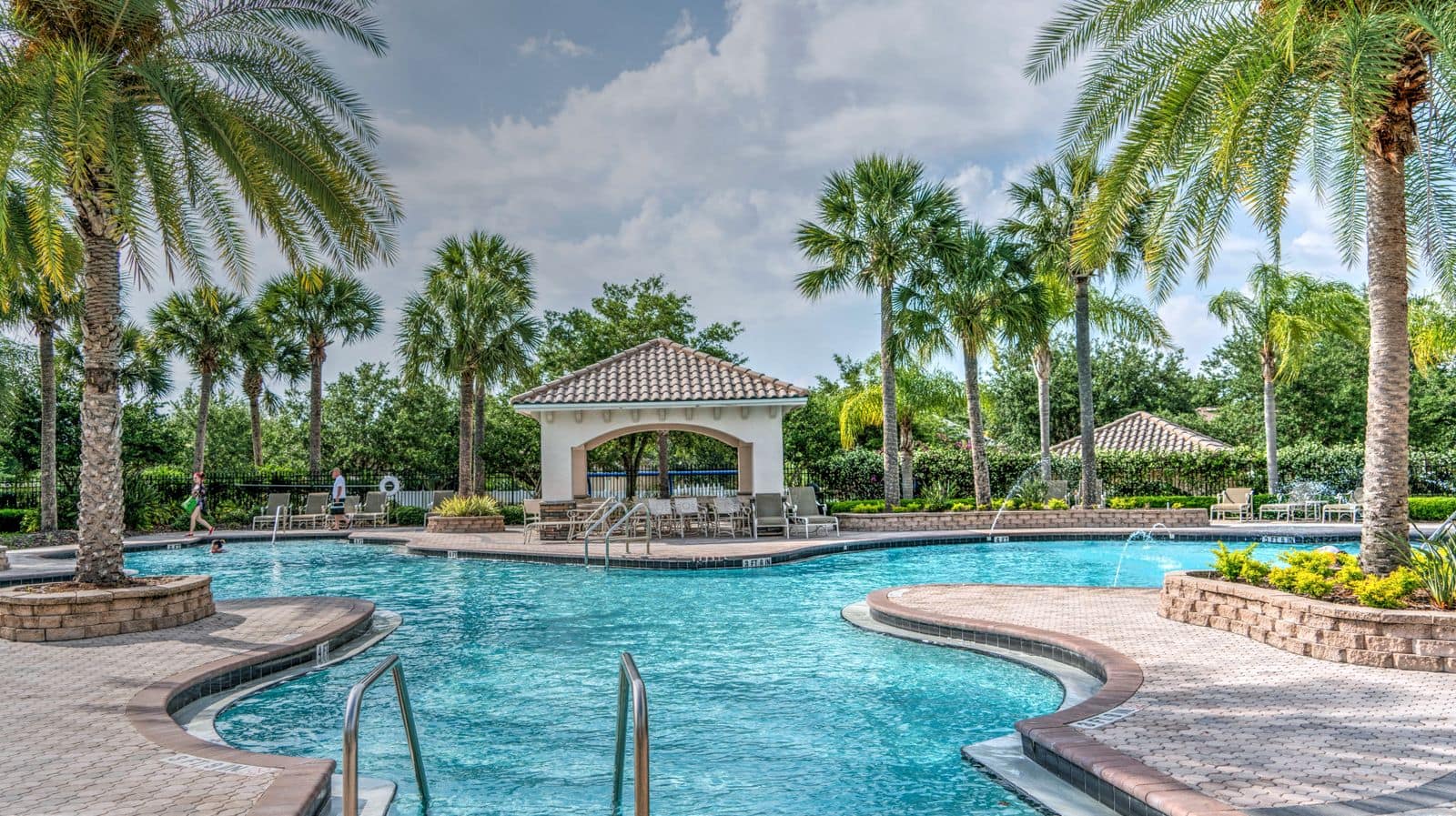 Piscina de un hotel todo incluido rodeada de palmeras